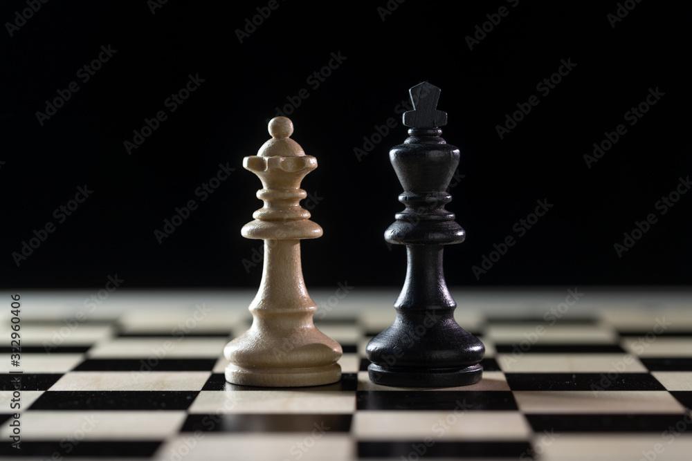Two chess pieces, white queen and black king side by side on a chessboard against a dark background, concept for diversity, gender equality and cooperation, copy space Stock Photo | Adobe Stock