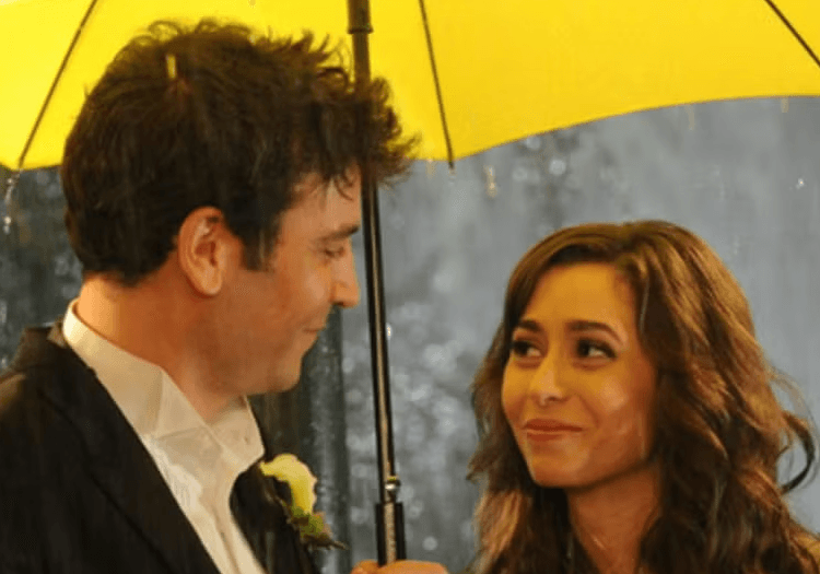Tracy and Ted standing under a yellow umbrella in How I Met Your Mother