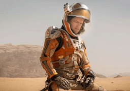 Matt Damon sitting in Martian soil in The Martian