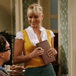 Penny holding a menu at the Cheesecake factory in The Big Bang Theory